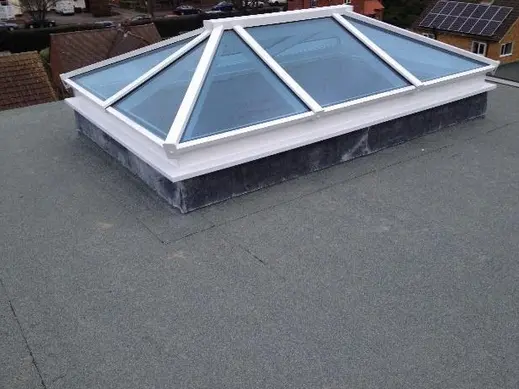 White framed roof lantern on a grey flat roof